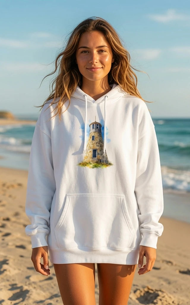 Woman wearing a white hoodie with a lighthouse design on a beach